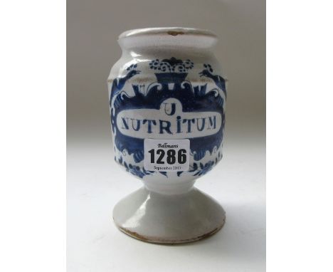 A tin glazed earthenware  drug jar, probably Dutch 18th century, detailed 'Nutrium' to the circular body (14.5cm high) an Eng