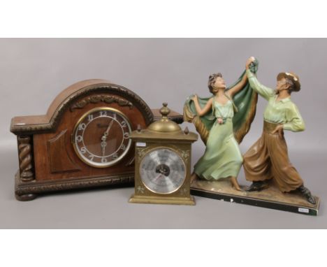 A large oak mantel clock, along with a plaster cast figure group and a brass barometer. 