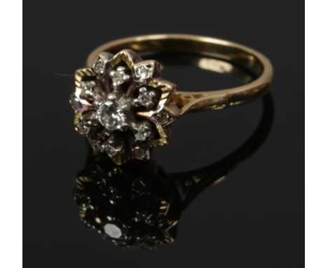 An 18ct gold and diamond snowflake cluster ring with chased border, 6.8 grams. Size R. 