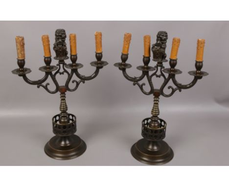 A pair of Dutch 18th century style bronze armorial four branch candelabra converted to tablelamps. Each with a central lion f