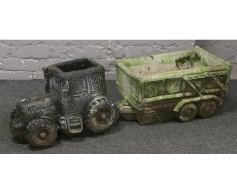 A large cast concrete planter formed as a tractor and trailer. 