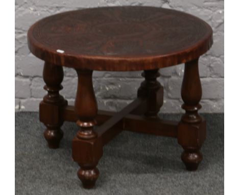 A circular Inca Mailman leather top occasional table raised on turned supports. 