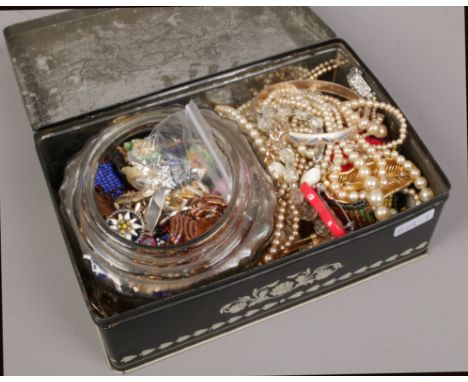 A tin of vintage costume jewellery to include beads, brooches, earrings, necklace etc. 