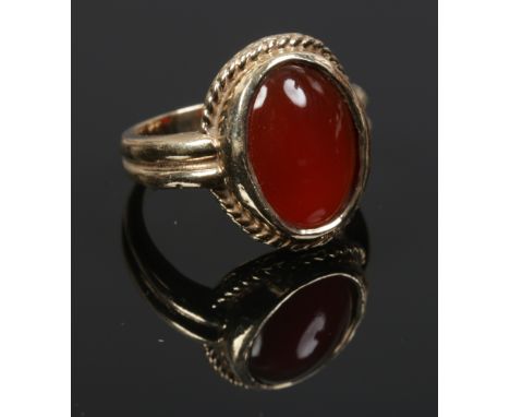 A 9ct gold and carnelian seal ring. With ropetwist border and reeded shoulders. 6.2 grams gross, size K. 