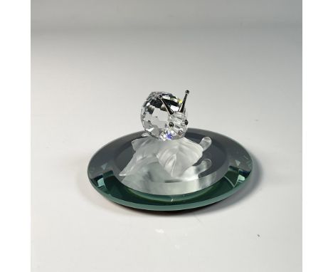 Adorable snail figure, crafted from clear crystal featuring frosted silver accent on a vine leaf, showing an intricate design