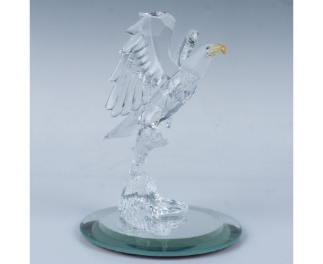 A majestic bald eagle perches proudly on a tree branch, its wings spread wide, featuring a frosted head, a striking yellow be