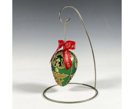 Handcrafted ornament adorned with gold decorative elements that include holly leaves and a stylized fleur de lis crown. The s