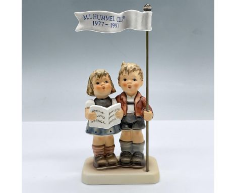 An adorable figure of a boy and a girl singling a song while holding an M.I. Hummel Club flag. Exclusive Edition 1977/1997 M.