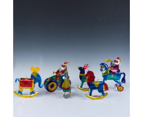 This collection of colorful ornaments features Santa in a car with wheels, Santa on a horse with wheels, A festive Santa cone