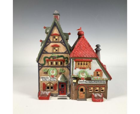 Hand painted porcelain piece featuring two distinct storefronts. Obbie's Books on the left, showcases festive wreaths and hol