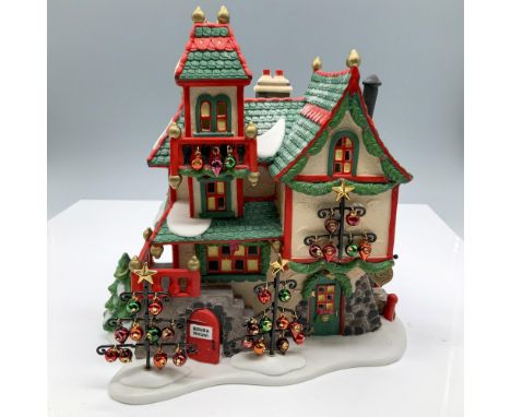 Hand painted porcelain house with festive green and red trim, snow dusted roofs, and tiny colorful ornaments hanging from the