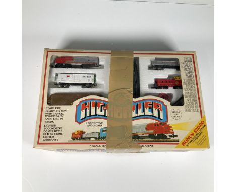 Train set includes a lighted locomotive and three cars. The set comes with a circular track, power pack, plug-in wiring, and 
