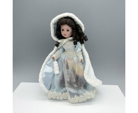 Gorgeous brunette porcelain figure of a woman draped in a stunning light blue dress and robe embellished with white trimming.