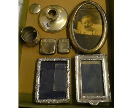 An oval silver photograph frame, Birmingham 1921, two other examples, two silver vesta cases, an inkwell and a bowl