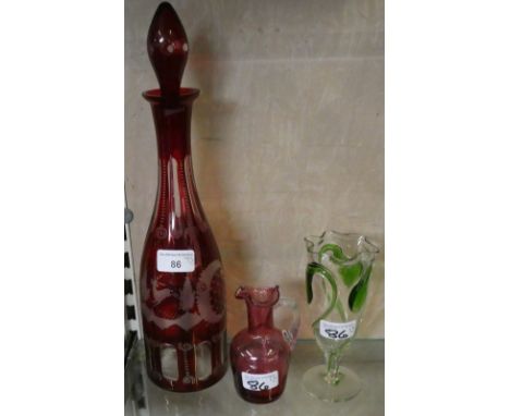 An early 20th century Bohemian red and clear flash cut decanter decorated with trees and buildings together with a cranberry 