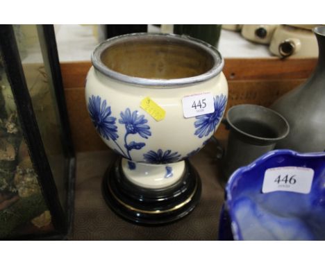 A heavy blue and white floral decorated ceramic urn