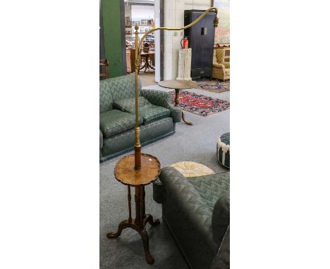 An Edwardian mahogany and brass ajustable standard lamp table, the revolving scroll arm above a pie crust table top over turn