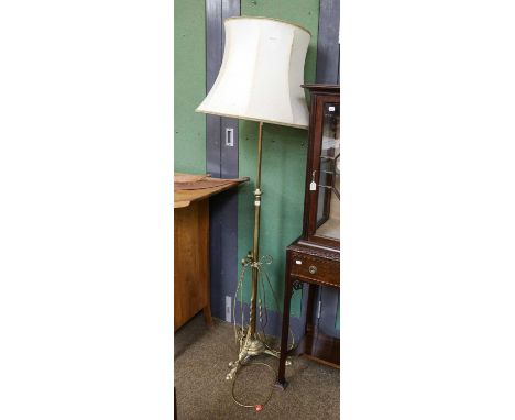 A brass standard lamp on scroll supports, 150cm (excluding fittings)