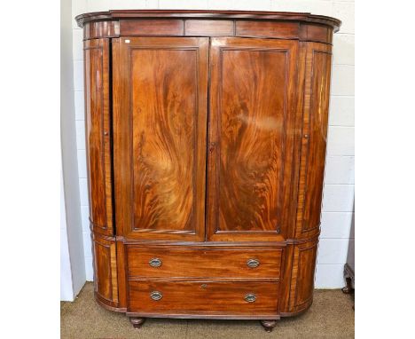 A Victorian mahogany bow fronted and breakfront wardrobe, the two central cupboard doors above a pair of drawers, flanked by 