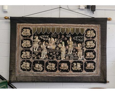 A South East Asian silkwork panel, decorated with figures and temple lions, 158cm by 106cm