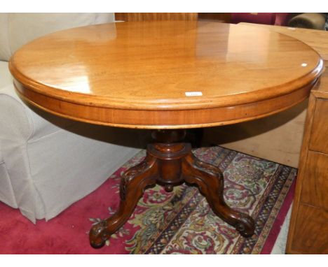 A Victorian mahogany circular tilt top dining table raised on a carved tripod base, diameter 105cm