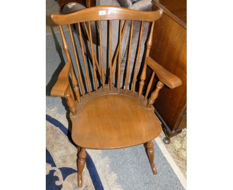 A stained pine rocking chair with stick back