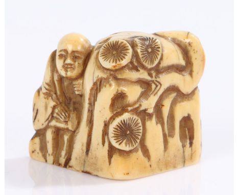 Japanese Meiji period ivory netsuke, of a figure standing by a rock with flowers, 3.6cm wide