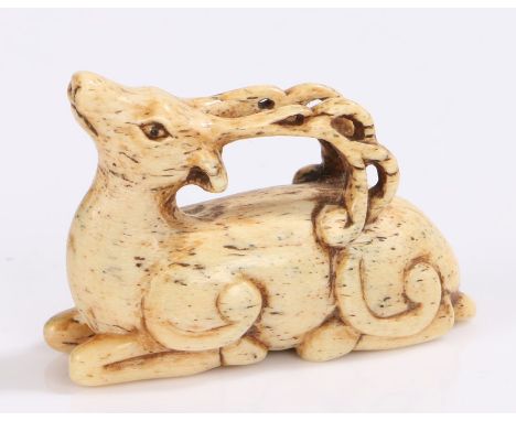 Japanese Edo period bone netsuke, 18th Century, as a reclining stag, 5.5cm long