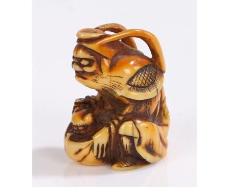 Japanese Meiji period ivory netsuke, of a crouched figure above Shishi in a sack, 3.5cm high