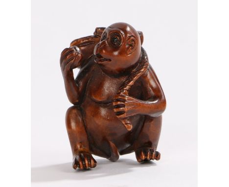 Japanese carved netsuke, as a monkey eating fruit, signed to the base, 4.4cm high