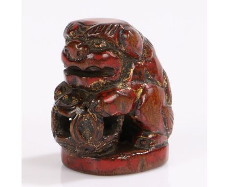 Japanese Edo period boxwood and lacquer netsuke, late 18th Century, seated Karashishi in seal form with forepaw rested, signe