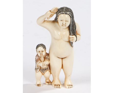 Japanese Meiji period ivory okimono, carved as a nude female above a boy, signed to the foot base, 7.5cm high