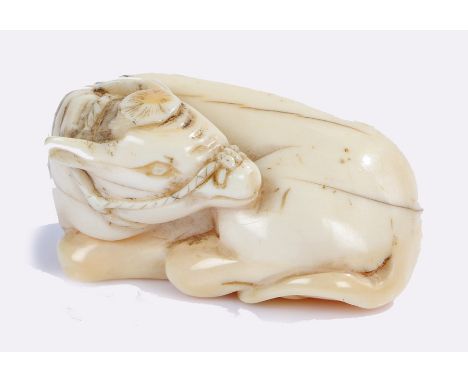 Japanese Meiji period ivory netsuke, a reclining cow, signed to the base, 4cm long