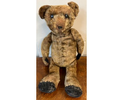 An early 20thC mohair teddy bear with black button eyes together with knitted trousers, jacket and hat. 41cm h. 