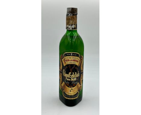 A bottle of Glenfiddich Pure Malt Scotch Whisky, over 8 years, Contents 26 2/3 Fl. ozs. Pre decimalisation label to top. 