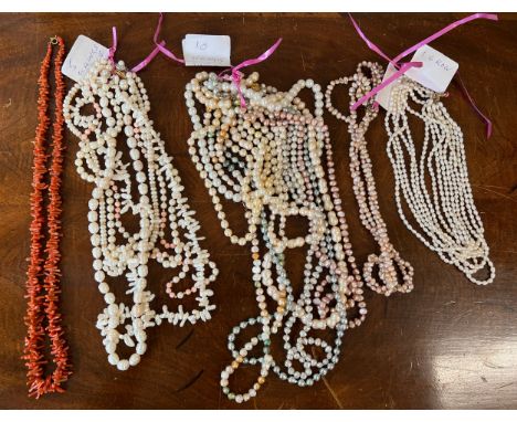 A large quantity of pearl bead necklaces together with a coral necklace. 