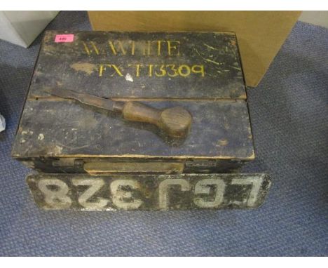 An early 20th century iron bound ebonized wooden box containing a wooden handled chisel with metal carrying handles and name 