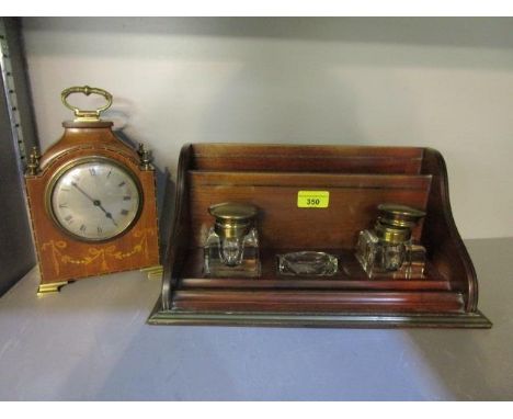 An early 20th century mahogany, brass mounted and inlaid mantle clock, with a desk set and inkwells 