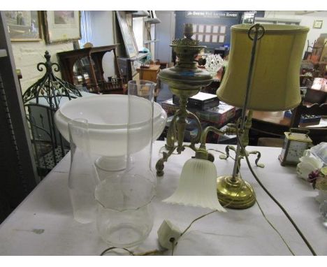 A messenger No 2 brass oil lamp with a milk glass shade and glass smoke funnel, an Arts &amp; Crafts brass table lamp with fa