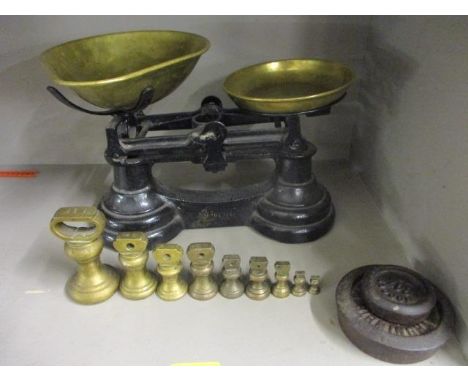 A set of brass and metal kitchen scales with additional weights 