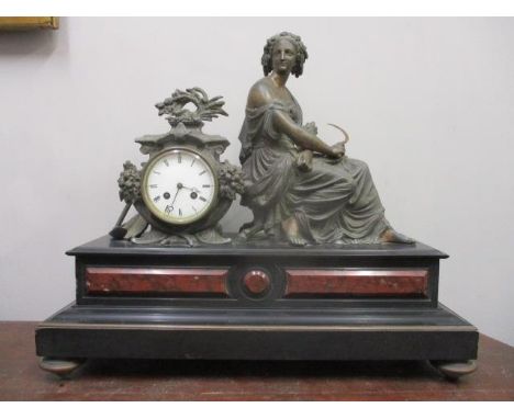 A late 19th century French spelter and marble mantel clock, surmounted by a woman and an enamelled dial 