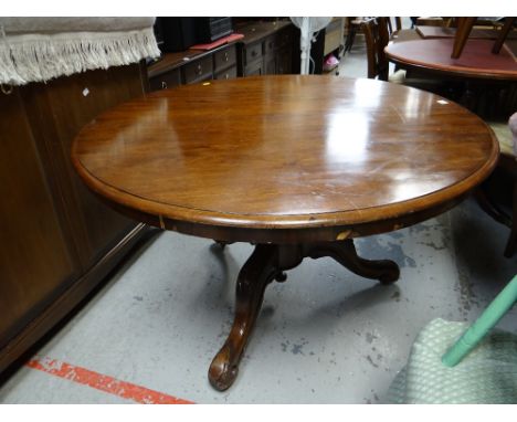 An antique mahogany tilt-top tripod dining table