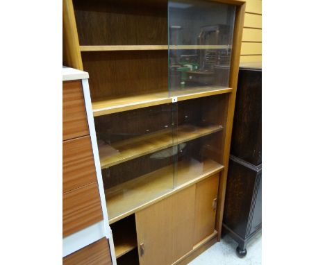 A vintage lightwood bookcase sliding glass door top above a sliding cupboard base