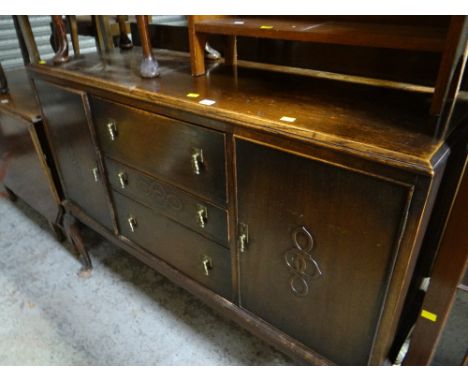 A vintage oak sideboard on raised feet with three cupboards flanked by two doors