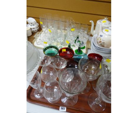Two trays of various drinking glasses including vintage coloured glass, champagne bowls, hock glasses etc