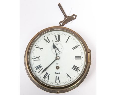 A brass bodied bulkhead/ship's clock, by Sestrel, Roman numerals, with regulator slot above seconds indicator, dial numbered 