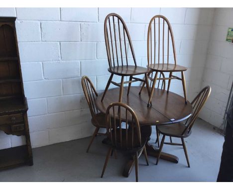 Ercol 'Golden Dawn' extending dining table of circular form, together with six Ercol stick back dining chairs, table 114cm in