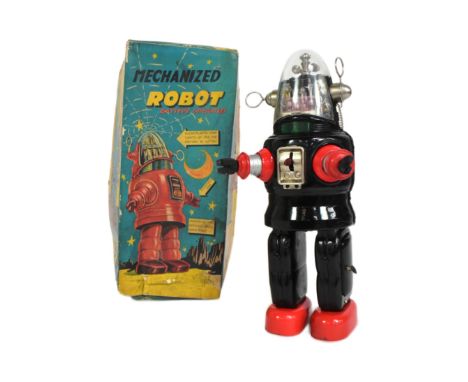A vintage Japanese tinplate battery operated mechanized Robby The Robot. Black and red with rubber hands and a light up face.
