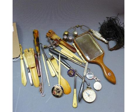 A miscellaneous collection of items to include a compass, badges, cameo brooch, and various bone items 