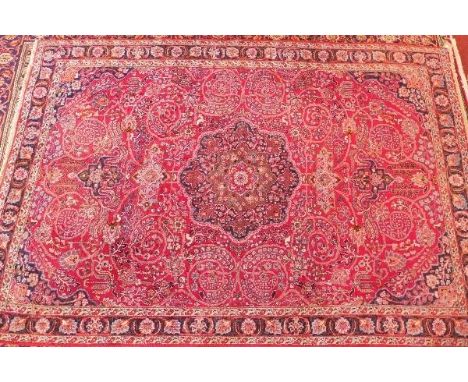 A fine North East Persian Meshad carpet, central double pendent medallion with repeating spandrels on a rouge field complimen